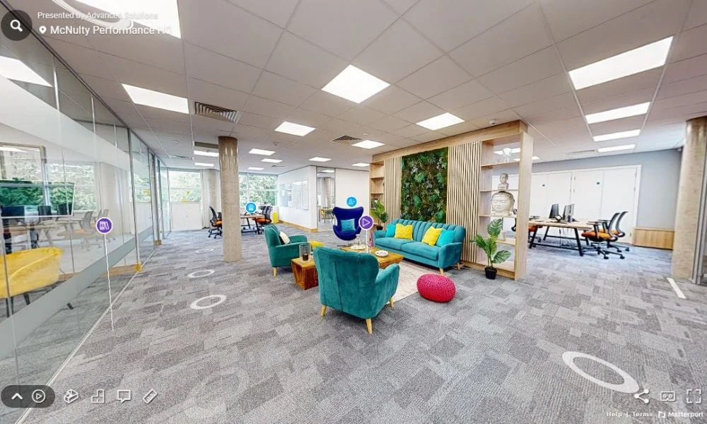 McNulty Performance Office Lounge showcasing a modern and inviting workspace with vibrant furniture and a green wall.